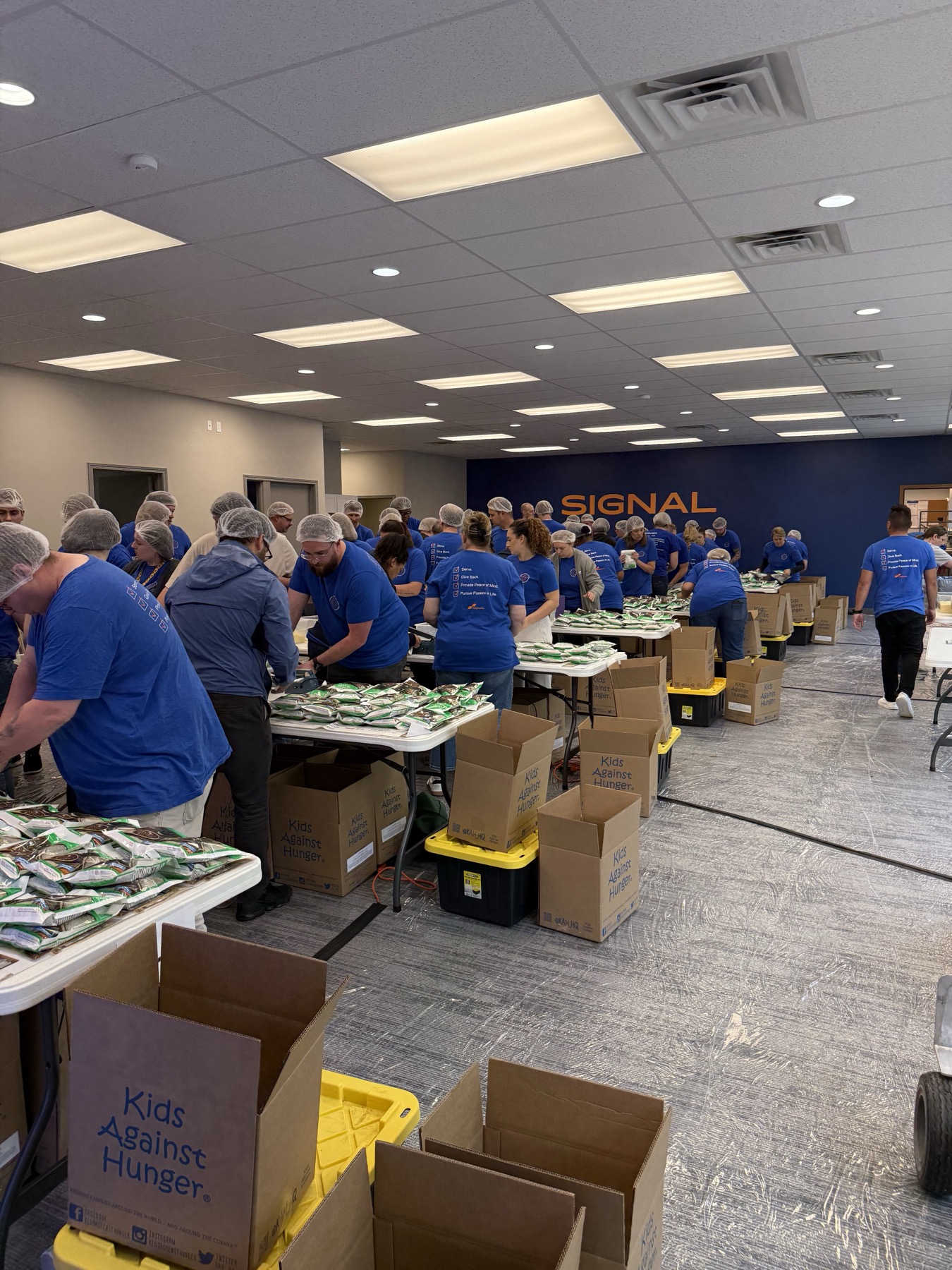 Signal franchisees packing meals at the Kids Against Hunger volunteer event